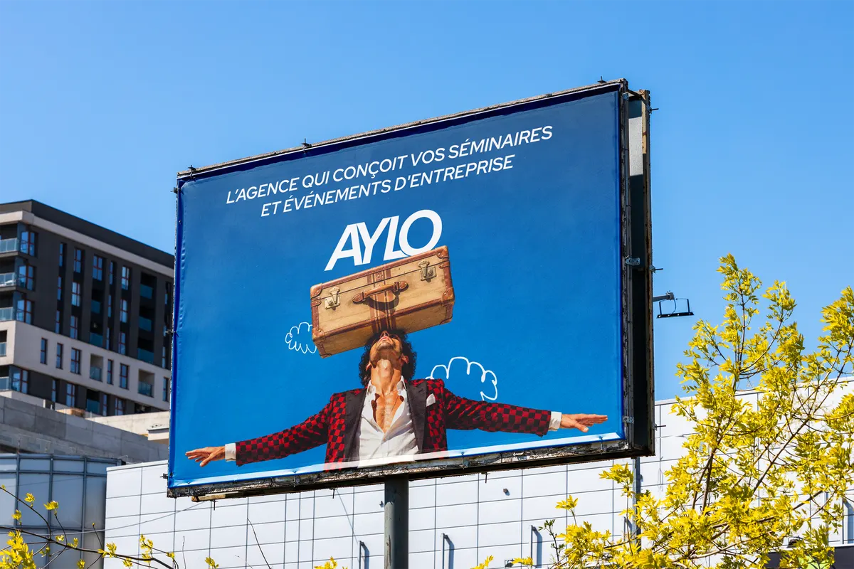 Panneau d'affichage AYLO « L'agence qui conçoit vos séminaires et événements d'entreprise » au-dessus d'une rue