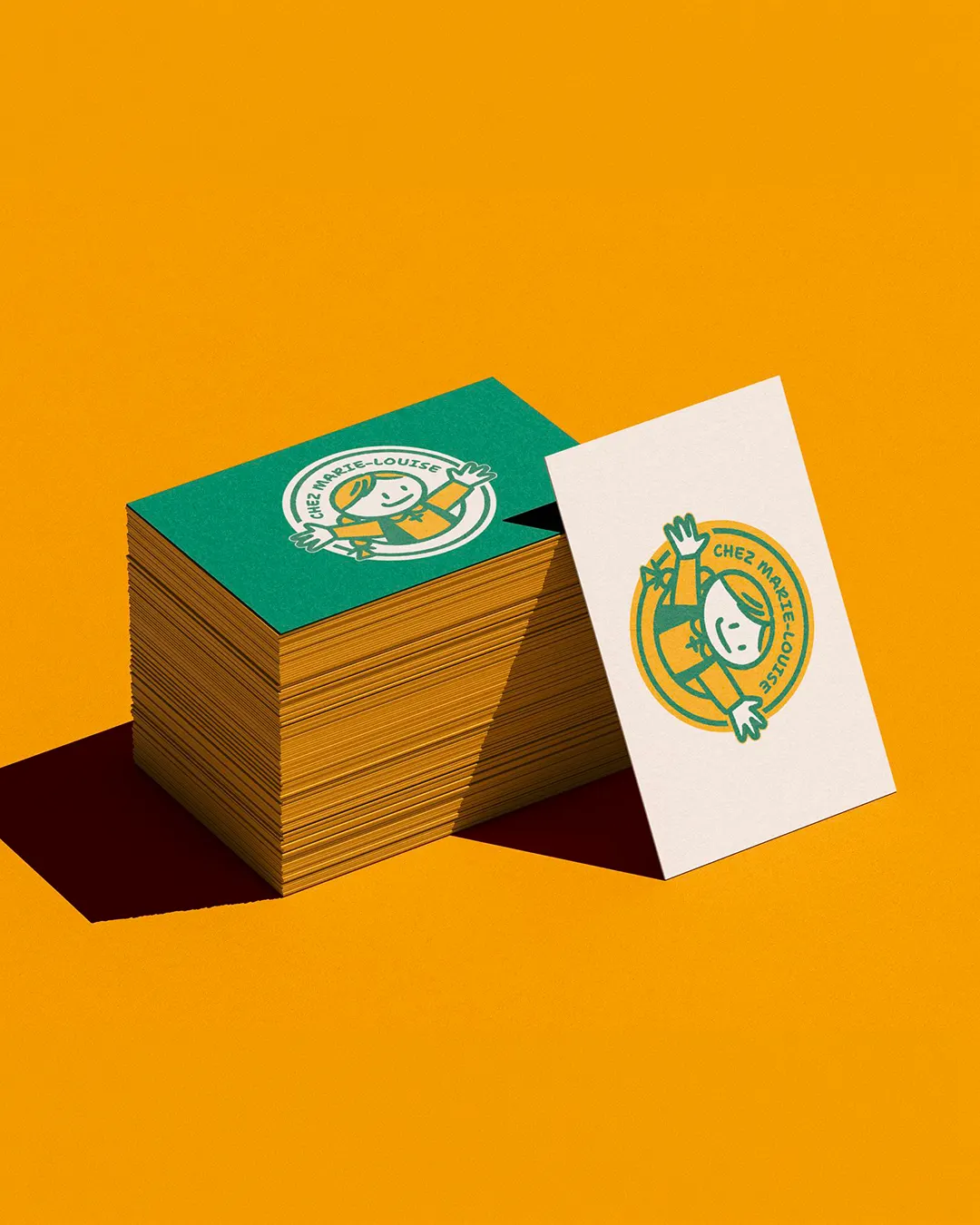 Cartes de visite vertes et crème au logo illustré de Chez Marie-Louise, sur fond jaune