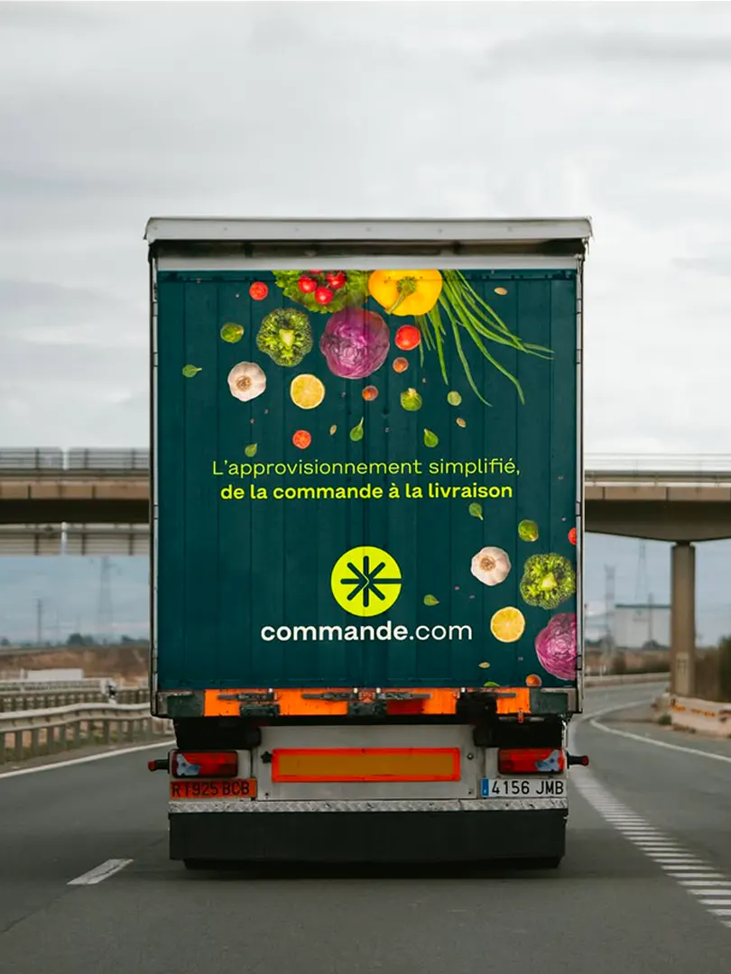 Arrière d'un camion de livraison Commande.com couvert de fruits et légumes