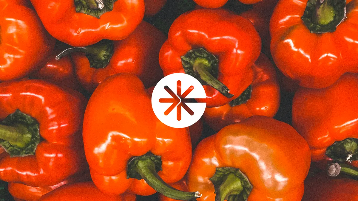 Logo étoile de Commande.com sur un fond de poivrons rouges