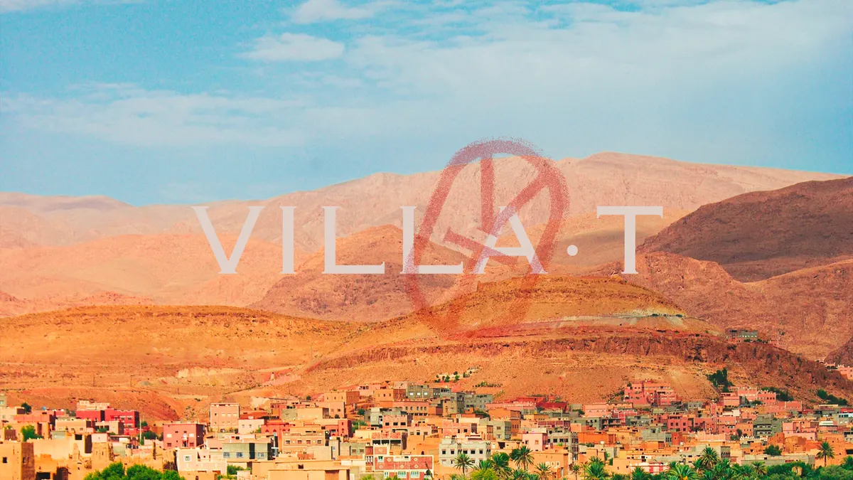 Nom VILLA·T et monogramme sur un paysage de montagnes et de village ocre au Maroc