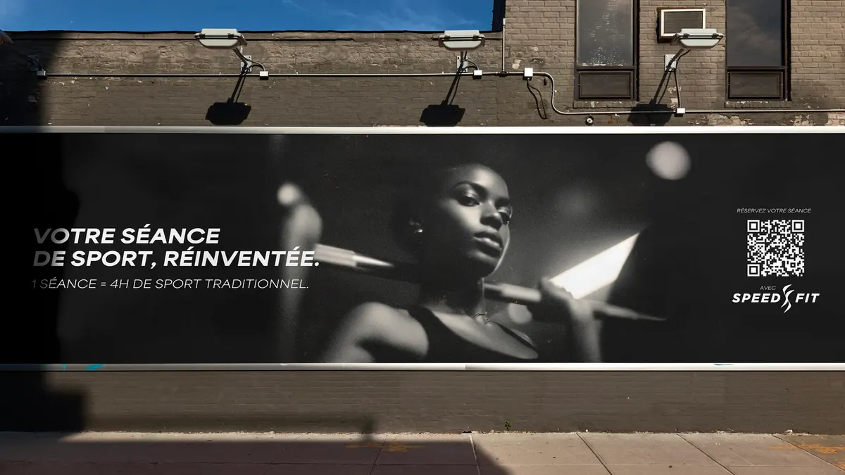 Bâche publicitaire Speedfit « Votre séance de sport, réinventée » en noir et blanc sur une façade