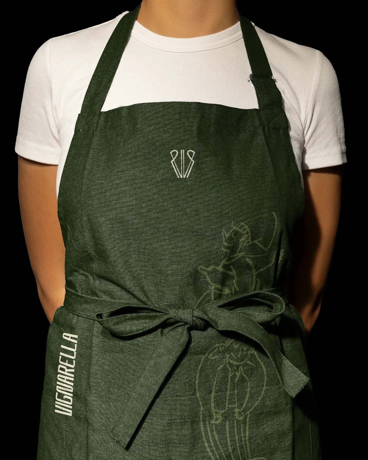 Tablier vert forêt brodé du monogramme VR et d'un personnage illustré de Vignarella