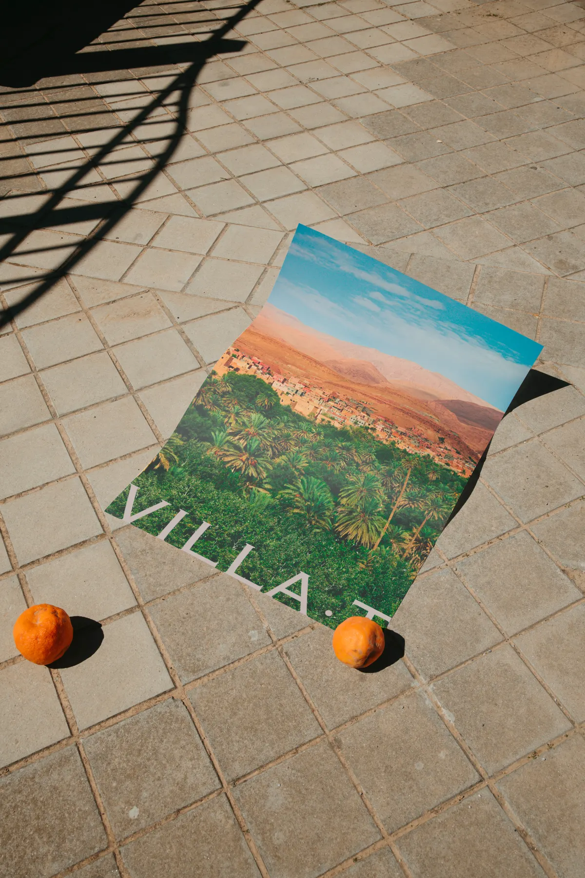 Affiche Villa·T d'un paysage marocain posée au sol avec deux oranges