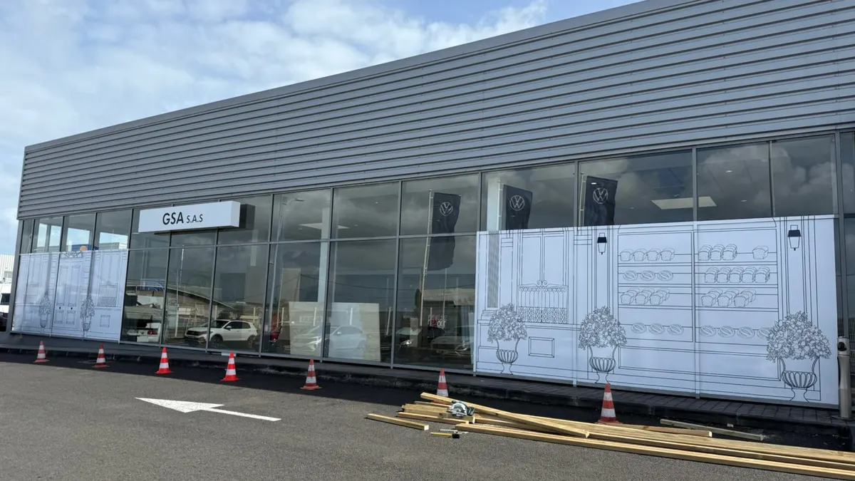 Façade de la concession Volkswagen en Guadeloupe habillée de l'illustration baroque de la campagne