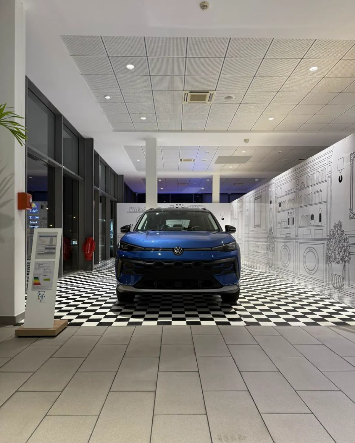 Nouveau T-Roc bleu exposé dans le pop-up illustré au sol en damier